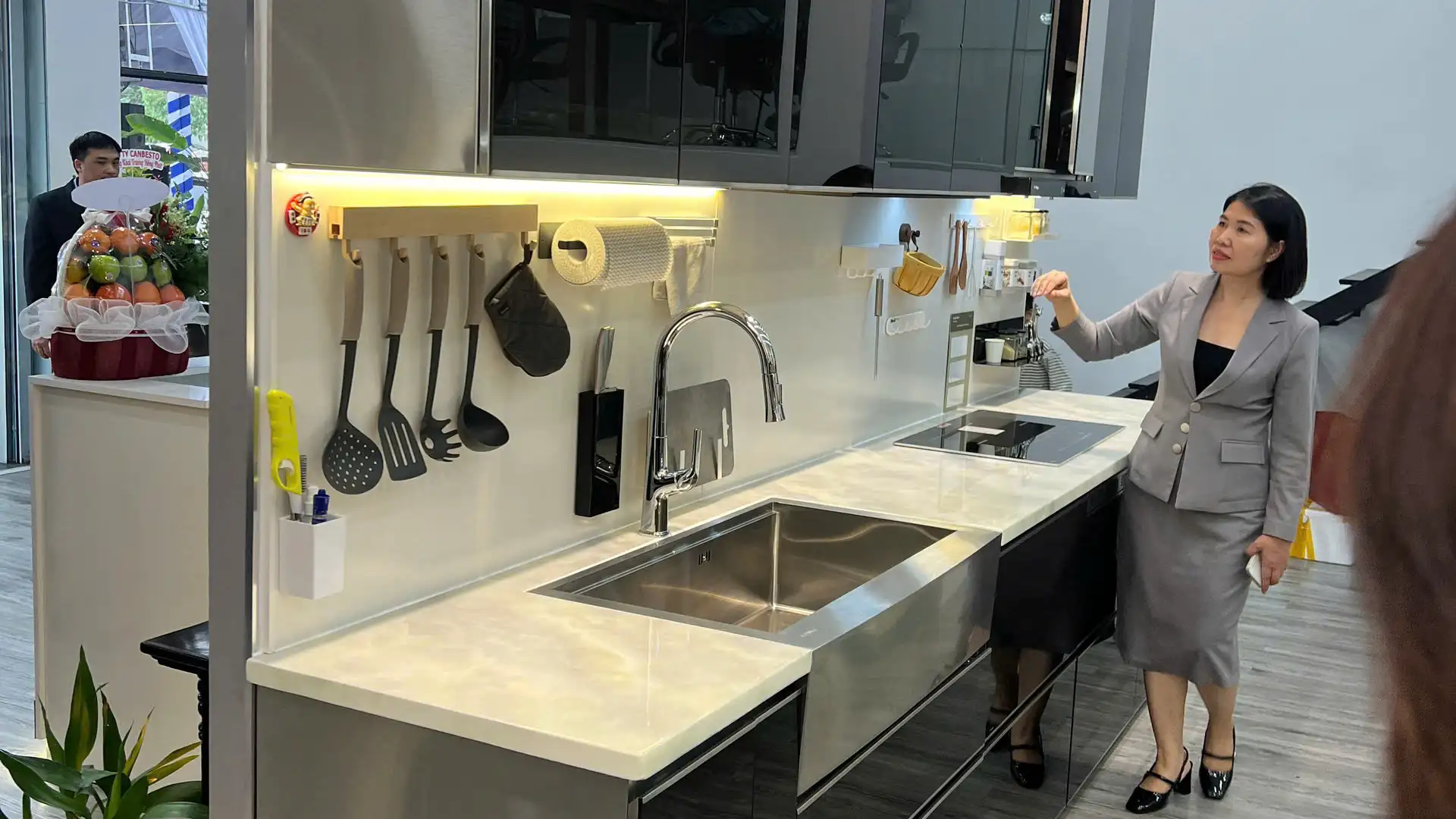 Khách hàng trải nghiệm bề mặt men sứ phẳng mịn của tấm ốp bếp Kurashi tại showroom đối tác ủy quyền